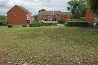 A large expanse of grass with houses in the background