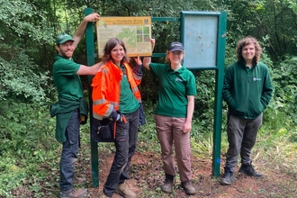 Conservation trainees standing next to a sign