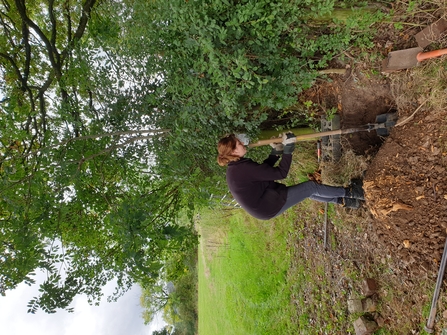 Woman digging a gatepost out by Iain Turbin