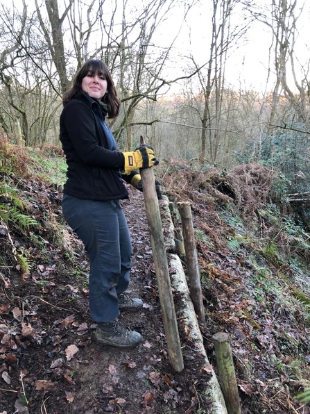 Woman holding a post for fencing