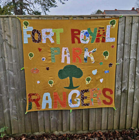 Handmade banner (from textiles) advertising the 'Fort Royal Park Rangers' - trees have also been stitched onto the golden background