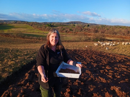 Trainee Jess scattering heather seed at Dropping Well Farm