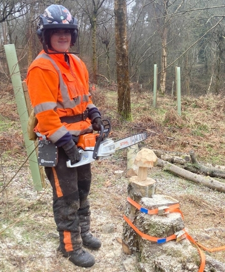 Conservation trainee Josie stood with a chainsaw